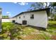 View of the home's exterior showing the backyard featuring fresh mulch and lawn at 4220 E Regnas Ave, Tampa, FL 33617