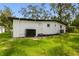 An exterior view of the home's backyard featuring black mulch and a fresh green lawn at 4220 E Regnas Ave, Tampa, FL 33617