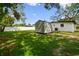 This backyard shows lush greenery, white fencing, and a storage shed at 4220 E Regnas Ave, Tampa, FL 33617