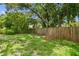 Fenced backyard with mature trees that create lots of shade at 4220 E Regnas Ave, Tampa, FL 33617