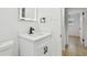 Bathroom displays floating vanity with modern fixtures, a toilet, and a door leading to the hall and shower at 4220 E Regnas Ave, Tampa, FL 33617
