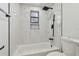 Bathroom displaying tub with shower, marble-style tiling, and modern fixtures including a black shower head at 4220 E Regnas Ave, Tampa, FL 33617