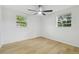 Bedroom features natural light through windows, a ceiling fan, and light wood-look floors at 4220 E Regnas Ave, Tampa, FL 33617
