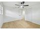 Bedroom featuring wood floor, ceiling fan, closet and views to a room through an open door at 4220 E Regnas Ave, Tampa, FL 33617