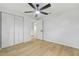 Bedroom with wood-look floors, closet, ceiling fan, and access to other rooms at 4220 E Regnas Ave, Tampa, FL 33617
