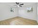 Bright bedroom with hardwood floors, ceiling fan, and natural light from two windows at 4220 E Regnas Ave, Tampa, FL 33617