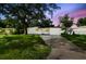 Charming exterior featuring a neatly maintained front yard, mature tree, and driveway at 4220 E Regnas Ave, Tampa, FL 33617
