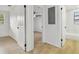 Hallway with wood-look floors provides access to a bedroom with ceiling fan and bathroom with tub at 4220 E Regnas Ave, Tampa, FL 33617