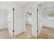Bright hallway showcases wood-look floors, multiple doorways, and access to various rooms within the home at 4220 E Regnas Ave, Tampa, FL 33617