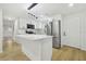 Modern kitchen with stainless steel appliances, a kitchen island, and sleek white cabinets at 4220 E Regnas Ave, Tampa, FL 33617