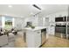 Open concept living space with kitchen island, modern lighting, and cozy seating arrangement at 4220 E Regnas Ave, Tampa, FL 33617