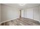 Bright bedroom with light gray walls, white trim, and wood-look floors with a closet and doorway at 4503 Jacona Dr, Hernando Beach, FL 34607