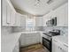 Bright kitchen features white cabinets, stone countertops, stainless steel appliances, and modern backsplash at 4503 Jacona Dr, Hernando Beach, FL 34607