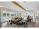 Staged living room with neutral furniture, ceiling fan, and sliding glass doors to the pool and dining area at 4503 Jacona Dr, Hernando Beach, FL 34607