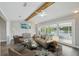 Staged living room with neutral furniture, ceiling fan, and sliding glass doors to the pool at 4503 Jacona Dr, Hernando Beach, FL 34607