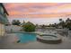 Backyard features a pool, hot tub, tiki hut, and canal access, all set against a beautiful sunset at 4503 Jacona Dr, Hernando Beach, FL 34607
