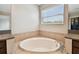 Relaxing bathroom featuring a soaking tub and a large window with natural light at 4544 Vermillion Sky Dr, Wesley Chapel, FL 33544