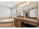 Luxurious bathroom featuring a garden tub, granite vanity, large mirror and plenty of natural light at 4544 Vermillion Sky Dr, Wesley Chapel, FL 33544