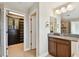 Bathroom showcasing double mirrors, granite counters, and a walk-in closet at 4544 Vermillion Sky Dr, Wesley Chapel, FL 33544