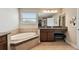 Elegant bathroom boasts a soaking tub, granite countertops, vanity, and plenty of space at 4544 Vermillion Sky Dr, Wesley Chapel, FL 33544