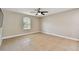 Neutral bedroom features tile flooring, ceiling fan, and arched window at 4544 Vermillion Sky Dr, Wesley Chapel, FL 33544