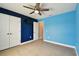 Bedroom with blue accent wall, a ceiling fan, tiled floor, and plenty of natural light at 4544 Vermillion Sky Dr, Wesley Chapel, FL 33544