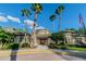 The community clubhouse, accentuated by palm trees, boasts architectural detailing and a welcoming entrance at 4544 Vermillion Sky Dr, Wesley Chapel, FL 33544