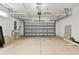Spacious two-car garage with an automatic door, plenty of shelving, and overhead storage at 4544 Vermillion Sky Dr, Wesley Chapel, FL 33544