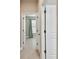 Hallway view with white doors and tile flooring leading to a room with a window and curtain at 4544 Vermillion Sky Dr, Wesley Chapel, FL 33544