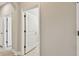 Hallway with multiple doors and tile flooring leading to various rooms at 4544 Vermillion Sky Dr, Wesley Chapel, FL 33544