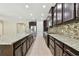 Spacious kitchen featuring granite countertops, stainless steel appliances, and dark wood cabinetry at 4544 Vermillion Sky Dr, Wesley Chapel, FL 33544