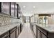 Spacious kitchen with an eat-in island, dark wood cabinets, and tile backsplash at 4544 Vermillion Sky Dr, Wesley Chapel, FL 33544
