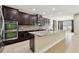 Modern kitchen with dark cabinetry, granite countertops, stainless steel appliances, and mosaic tile backsplash at 4544 Vermillion Sky Dr, Wesley Chapel, FL 33544