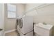 Bright laundry room features a white washer and dryer set and a convenient utility sink at 4544 Vermillion Sky Dr, Wesley Chapel, FL 33544