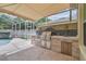 Covered outdoor kitchen with stainless steel grill, sink, and ample counter space at 4544 Vermillion Sky Dr, Wesley Chapel, FL 33544