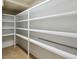 Walk-in pantry featuring adjustable white shelving for optimal storage at 4544 Vermillion Sky Dr, Wesley Chapel, FL 33544