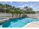 Sparkling screened-in pool and spa with travertine tile deck at 4544 Vermillion Sky Dr, Wesley Chapel, FL 33544