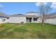 Large backyard with green grass, a back patio, and a white picket fence at 5027 Autumn Ridge Dr, Wesley Chapel, FL 33545