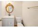 Powder bathroom with decorative mirror, white vanity, toilet, and towel rack at 5027 Autumn Ridge Dr, Wesley Chapel, FL 33545