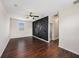 Bedroom featuring hardwood floors, ceiling fan, bright window and decorative wood accent wall for mounting television at 5027 Autumn Ridge Dr, Wesley Chapel, FL 33545