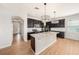 Modern kitchen with a large island, granite countertops, and dark cabinets, seamlessly connecting to living area at 5027 Autumn Ridge Dr, Wesley Chapel, FL 33545