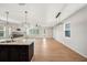Open living room with hardwood floors, modern lighting, white brick fireplace, and bright windows at 5027 Autumn Ridge Dr, Wesley Chapel, FL 33545