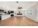 Open-concept living space featuring hardwood floors, a modern fireplace, and adjacent kitchen area at 5027 Autumn Ridge Dr, Wesley Chapel, FL 33545