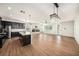 Open-concept living area featuring hardwood floors, modern lighting, fireplace, and kitchen island at 5027 Autumn Ridge Dr, Wesley Chapel, FL 33545