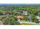 Aerial view of a lush community with mature trees, well-maintained lawns, and a home with pool at 512 Crystal Grove Blvd, Lutz, FL 33548