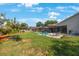 Expansive backyard featuring lush green grass, patio with furniture and a screened-in lanai at 512 Crystal Grove Blvd, Lutz, FL 33548