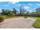 Spacious backyard with a brick-paved patio and a cozy fire pit area, surrounded by lush landscaping at 512 Crystal Grove Blvd, Lutz, FL 33548