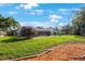 Backyard featuring lush green grass, mature trees, patio with furniture and a screened-in lanai at 512 Crystal Grove Blvd, Lutz, FL 33548