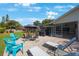 Backyard patio featuring outdoor seating, grill, lounge chairs and screened in lanai at 512 Crystal Grove Blvd, Lutz, FL 33548