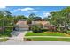 Beautiful single-Gathering home with lush landscaping, mature trees, and a well-maintained lawn at 512 Crystal Grove Blvd, Lutz, FL 33548
